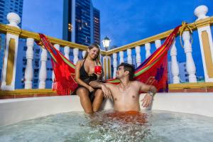 a man and a woman sitting in a hot tub at Hotel Baluarte Cartagena Boutique in Cartagena de Indias