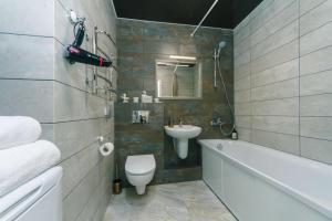 a bathroom with a sink and a toilet and a bath tub at Апартаменты Гмыри 12б in Kyiv +4 photos
