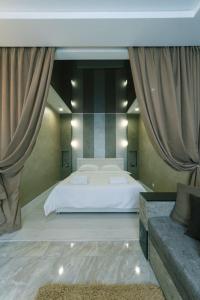 a bedroom with a white bed and a couch at Апартаменты Гмыри 12б in Kyiv