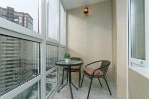- Balcón con mesa pequeña y 2 sillas en Апартаменты Гмыри 12б, en Kiev