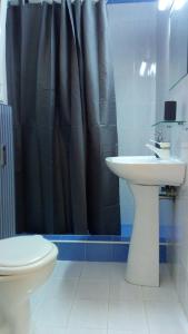 ein Bad mit einem schwarzen Duschvorhang und einem Waschbecken in der Unterkunft Theo's loft in Athen + 10 Fotos