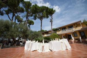 een groep tafels met witte tafelkleden voor een gebouw bij Villa Del Colle in Monte San Giovanni Campano