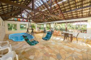 a living room with hammocks and a table and chairs at Pousada Lago Azul in Monte Verde