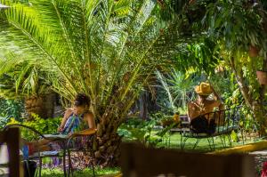 two people sitting in chairs under a palm tree at Casa Losodeli & Coworking- Adults Only in Puerto Escondido