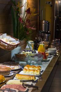 a buffet with many different types of food on a table at San Diego Lancaster Teófilo Otoni in Teófilo Otoni