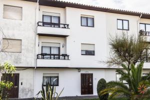 an exterior view of a white building with black windows at Nine Senses in Furadouro