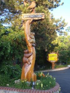 een standbeeld van beren op een boom met een bord bij Giant Oaks Lodge in Running Springs