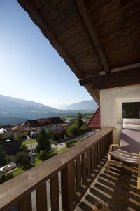 einen Holzbalkon mit einem Stuhl und Aussicht in der Unterkunft Ferienwohnung Monika Knoflach in Innsbruck