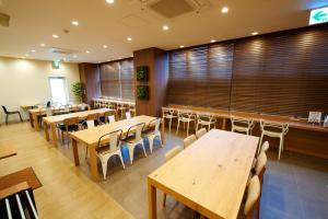 a dining room with wooden tables and chairs at Super Hotel JR Nara Ekimae Sanjo Dori in Nara