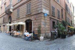 un grupo de personas sentadas en mesas fuera de un edificio en Il Nido en Roma