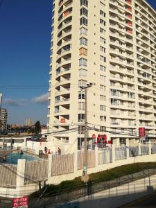 un edificio blanco alto con una piscina frente a él en Departamento La Herradura, en Coquimbo