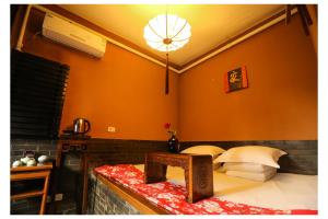 1 dormitorio con 1 cama con pared de color naranja en Pingyao Zheng Garden Inn, en Pingyao