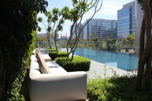 a row of white couches sitting next to a pool at The Den, Bengaluru in Bangalore