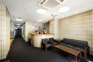 a woman standing at a bar in a waiting room at Hotel Sun Garden Matsuyama in Matsuyama