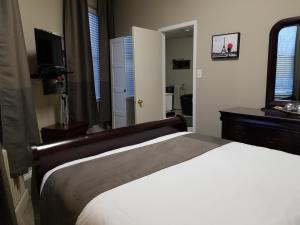 a bedroom with a white bed and a television at 1-Bedroom Cozy Suite #26 by Amazing Property Rentals in Gatineau