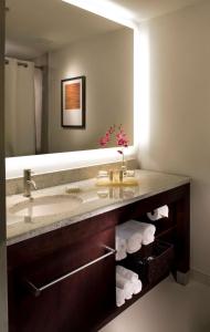 a bathroom with a sink and a mirror and towels at Hyatt Regency Suites Atlanta Northwest in Atlanta