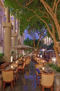 a restaurant with tables and chairs and trees at Hyatt Regency Greenwich in Greenwich