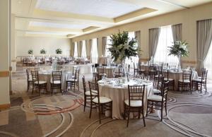 un salón de banquetes con mesas y sillas blancas en Hyatt Rosemont Near O'Hare en Rosemont