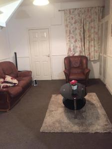 ein Wohnzimmer mit 2 Ledersesseln und einem Couchtisch in der Unterkunft Double Room Home Stay Manchester in Manchester