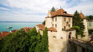 a castle on a hill next to a body of water at BodenSEE Apartment 1 - 4 Daisendorf bei Meersburg in Daisendorf