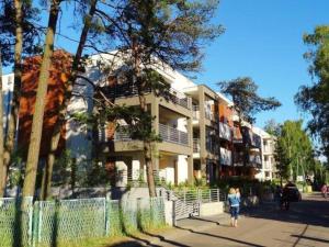 a woman walking down a sidewalk in front of a building at Apartment Panorama in Międzywodzie