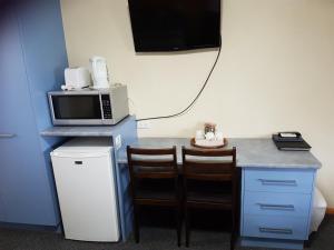 a kitchen with a microwave and a table at Kingaroy Country Motel in Kingaroy