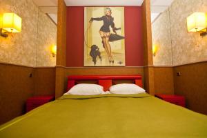 a bedroom with a bed with a painting on the wall at Road Star Hotel in Dnipro