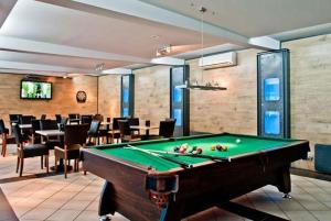 a billiard room with a pool table and a restaurant at Baltic Inn in Pogorzelica