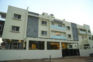 a large white building with a lot of windows at Samarth Residency in Hospet
