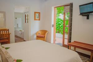 a bedroom with a bed and a sliding glass door at Aan de Oever Guesthouse in Swellendam