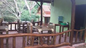 porche con mesa de madera y sillas en el patio en Kuta Mountain Bungalows, en Kuta Lombok