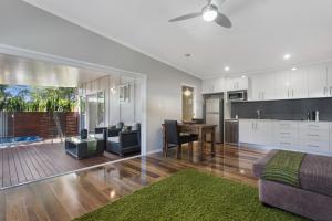 a kitchen and living room with a couch and a table at Pandanus Spa Cottage in Coolum Beach