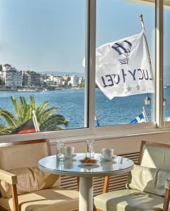 einen Tisch in einem Zimmer mit Blick auf das Wasser in der Unterkunft Lucy Hotel in Chalkida