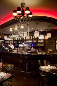 a bar in a restaurant with a man behind the counter at L'Olympique 1924 in La Garenne-Colombes