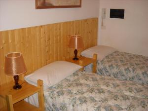 Dos camas en una habitación con dos lámparas. en B&B Hope, en Bolonia