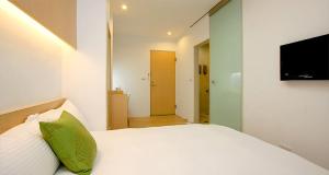 1 dormitorio con cama blanca y almohada verde en Hao Yang II, en Yuli
