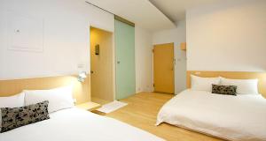 ein Hotelzimmer mit 2 Betten und einem Flur in der Unterkunft Hao Yang II in Yuli