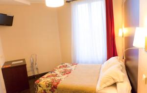 a small bedroom with a bed and a window at L'Olympique 1924 in La Garenne-Colombes