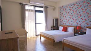 a hotel room with two beds and a window at Warm Breeze Stay in Hualien City