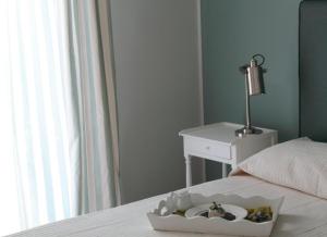 a bed with a tray with dolls in it next to a table at B&B Le Biciclette in San Vito lo Capo