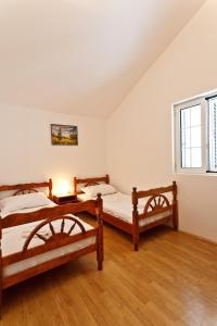 a bedroom with two beds and a table with a lamp at Apartments Kovinic in Tivat