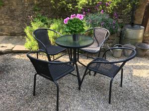 a table and four chairs with a table and flowers at Rose Cottage in Bakewell +2 photos