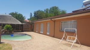a patio with a chair and a swimming pool at Amberlight Self Catering Accommodation in Krugersdorp