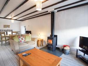 a living room with a wood stove in it at Laurel Cottage in Ulverston