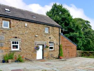 an old brick house with a white door at The Loft in Dronfield