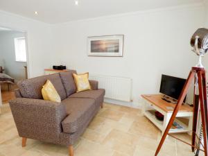 a living room with a couch and a television at The Hideaway in Verwood