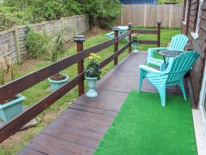 a wooden deck with two chairs and a table at The Chalet in Potton