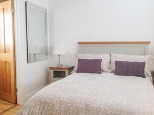 una camera da letto con un grande letto con cuscini viola di The Hideaway a Verwood