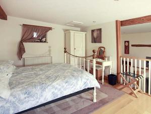a bedroom with a large bed and a desk at Cow Byre Cottage in Pickering