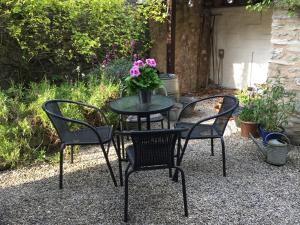 un tavolo e sedie con un vaso di fiori sopra di Rose Cottage a Bakewell